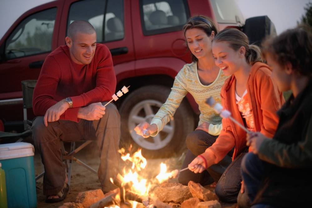 Family roasing marshmallows together.